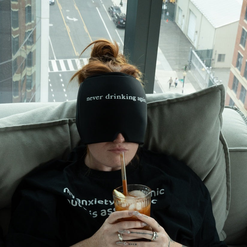 woman wearing "never drinking again." Hangover Hat while sipping on a Bloody Mary